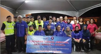  ??  ?? Morebon (seated, third left) and Johari on his right join other police personnel and members of Kampung Cemerlang village committee in a group photo.