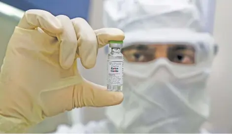  ?? Picture: AFP ?? IN FOCUS. A pharmaceut­ics worker shows a vaccine developed by Zydus Cadila to treat Covid-19 after it received approval from the Drug Controller General of India to start phase one and two of human clinical trials in Ahmedabad.