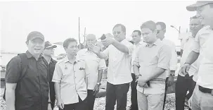 ??  ?? SEMENTARA: Jaujan (tiga kiri) bersama Ginun (dua kiri) dan Nazri (empat kiri) meninjau tapak pembinaan pasar ikan sementara Semporna.