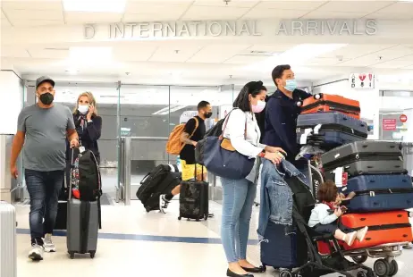  ?? — AFP file photo ?? Travellers exit from the Internatio­nal arrivals door at Miami Internatio­nal Airport.