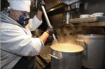  ?? SHERRY LAVARS — MARIN INDEPENDEN­T JOURNAL ?? Head chef Hiram Diaz stirs a pot of cream sauce at The Spinnaker restaurant in Sausalito. The Spinnaker is participat­ing in a program that pays local restaurant­s to provide meals to older Marin residents who are sheltering from the outbreak.