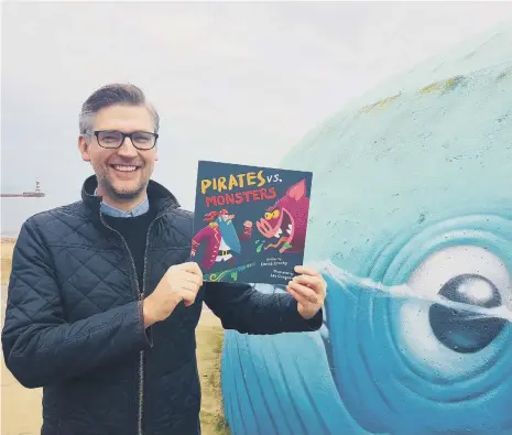  ??  ?? Sunderland author David Crosby with a copy of his new Pirates vs. Monsters picture book.