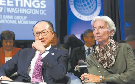  ?? Reuters-Yonhap ?? World Bank President Jim Yong Kim, left, and IMF Managing Director Christine Lagarde attend a Developmen­t Committee plenary during the IMF/World Bank annual meetings in Washington, D.C., Saturday.