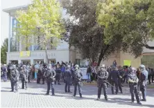  ?? Ap photo ?? IS THIS HELPING? Berkeley, Calif., police protect a city rally in favor of Ann Coulter, whose college lecture was canceled due to fears of violent outbursts.