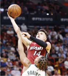  ?? — AFP photo ?? Tyler Herro of the Miami Heat goes up for a layup against Justin Robinson of the Milwaukee Bucks.