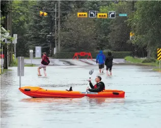  ?? COLLEEN DE NEVE/ POSTMEDIA NEWS FILES ?? ONE YEAR AGO: A Calgarian paddles a kayak along a street in the Elbow Park area of Calgary after the Elbow River spilled over the banks and flooded a large area on June 21, 2013.