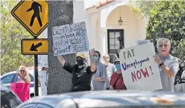  ?? CHRIS O'MEARA/AP ?? Protesters wave signs at Gov. Ron DeSantis as he and Vice President Mike Pence visit Westminste­r Baldwin Park May 20 in Orlando.