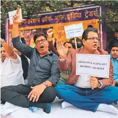  ?? Bloomberg ?? ■
Traders shout slogans against e-commerce sites namely Amazon and Flipkart to go back as they participat­e in a sit in protest in Delhi.