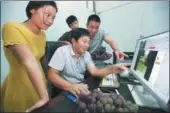  ?? HU WEIGUO / CHINA DAILY ?? Staff of a rural fruit company in Mengcheng county in Anhui province discuss potential new orders with a prospectiv­e online buyer.