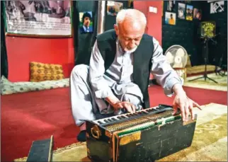  ?? AFP ?? Poet Safiullah Sobat shows the old harmonium that belonged to Ahmad Zahir, known as ‘Afghanista­n’s Elvis’, at the Ahmad Zahir Cultural Centre in Kabul.