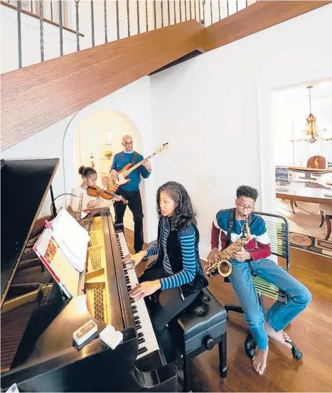  ?? GLEN STUBBE/STAR TRIBUNE ?? Architect Alicia Belton designed the staircase in her Lake of the Isles home to accommodat­e her family piano. The Beltons —Alicia and Marc and their children Gabrielle, 11, and Alexander, 14 — are a musical family.