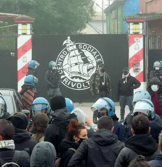  ??  ?? Perquisizi­one
La piccola folla di attivisti davanti all’ingresso del centro sociale
Rivolta, bloccato da un cordone di agenti in tenuta antisommos­sa