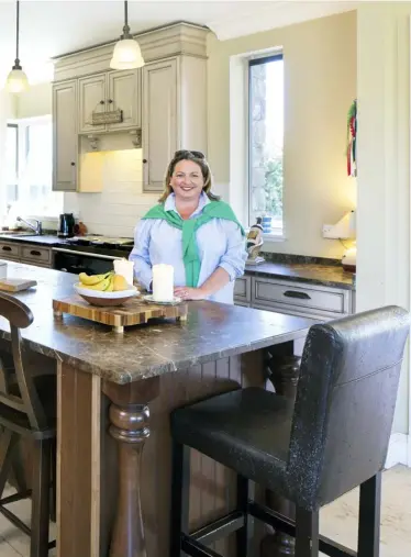  ??  ?? ABOVE: Marita Varley in the open-plan kitchen. The granite is local, but all the units are from Home Depot in the United States and the lighting is from Restoratio­n Hardware there