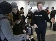  ?? SETH WENIG — ASSOCIATED PRESS ?? In this March 15 photo, an Uber representa­tive helps travelers find rides with Uber at LaGuardia Airport in New York. Upstate New York holds a dubious distinctio­n in the continenta­l United States: It’s the largest area without app-based ride-hailing...