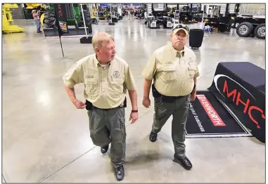  ?? (Arkansas Democrat-Gazette/Staci Vandagriff) ?? Assistant Chief Russ Lancaster (left) and agent Justin Smith of the Department of Agricultur­e’s law enforcemen­t team work Friday during the Southwest Forest Expo at the Hot Springs Convention Center.