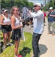  ?? VICKIE FULKERSON/THE DAY ?? Stonington girls’ tennis coach George Crouse prepares to place a championsh­ip medal around the neck of senior and No. 1 singles player Maddie Hamm after the Bears defeated Hand 6-1 in Saturday’s Class M state championsh­ip match at Wesleyan University.