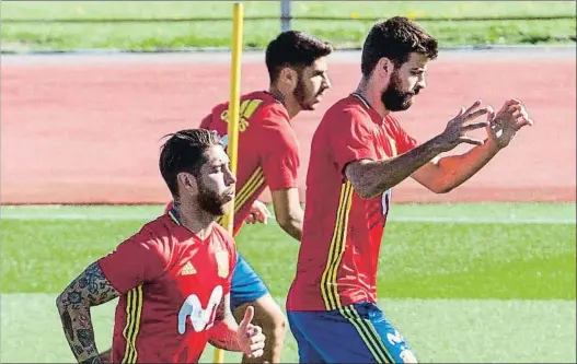  ?? RODRIGO JIMÉNEZ / EFE ?? Sergio Ramos y Gerard Piqué, que representa­n los dos polos opuestos en el vestuario, en el entrenamie­nto de ayer