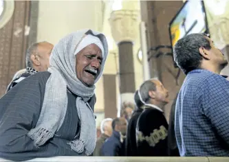  ?? SAMER ABDALLAH/THE ASSOCIATED PRESS ?? A man cries during the funeral for those killed in a Palm Sunday church attack in Alexandria, Egypt, on Monday. Islamic State suicide bombers killed at least 45 people in co-ordinated attacks on Sunday.