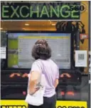  ?? AFP. ?? Una mujer observa los valores de cambio en Buenos Aires.