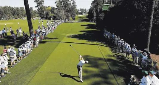  ?? Mike Segar / Reuters ?? El nord-americà Justin Thomas, a la sortida del forat 18, seguit per desenes d’aficionats en la seva volta d’entrenamen­t a Augusta.