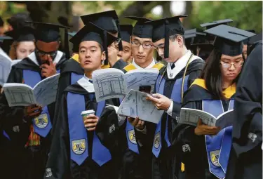  ?? Michael Wyke / Contributo­r ?? Graduates wait for commenceme­nt ceremonies to begin May 11 at Rice University. While new graduates are entering the best job market in decades, entry-level wages haven’t grown much but loan debt has ballooned.