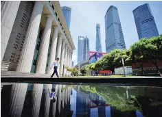  ??  ?? A man walks at Lujiazui financial district of Pudong in Shanghai, China July 17. Sharp drops in highly speculativ­e small-cap stocks pulled China’s major stock indexes lower yesterday, offsetting stronger-than-expected economic growth data.