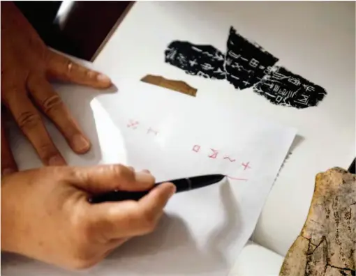  ??  ?? At present, identifica­tion of oracle bone inscriptio­ns has become a discipline involving diverse subjects such as archeology, history and philology. Pictured is Huang Tianshu explaining how to identify a specific character on an oracle bone. by Ma Yue