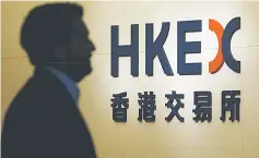  ??  ?? A man walks past the entrance to the Hong Kong Exchanges bearing a new logo in Hong Kong, China. — Reuters photo