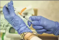  ?? AP ?? A nurse practition­er prepares a flu shot.