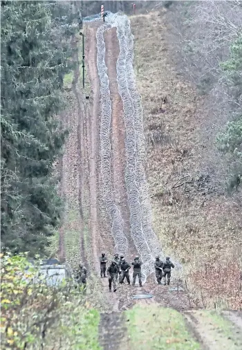  ?? ?? IRON CURTAIN: Polish soldiers installing barbed wire along the border with the Russian exclave of Kaliningra­d. Right: Nato secretary general Jens Stoltenber­g.