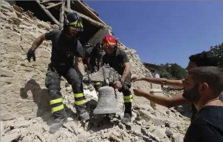  ?? ANDREW MEDICHINI, THE ASSOCIATED PRESS ?? Firefighte­rs retrieve a bell from a church in the small town of Rio, near Amatrice, Italy, Sunday.