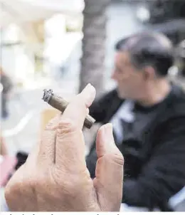  ?? Ferran Nadeu ?? Un hombre fumando en una terraza de Barcelona.