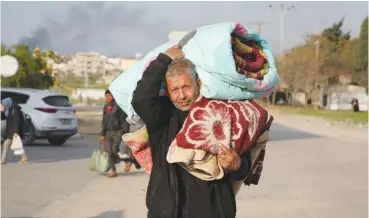  ?? AP PHOTO/HATEM ALI ?? Palestinia­ns fleeing the Israeli offensive on Khan Younis arrive Wednesday at Rafah in the Gaza Strip.