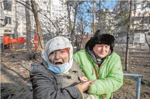  ?? // AFP ?? Una mujer es evacuada de un edificio en Kiev que ha sufrido un incendio tras un ataque