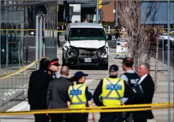  ?? AARON VINCENT ELKAIM/THE CANADIAN PRESS VIA AP ?? POLICE ARE SEEN NEAR a damaged van after in crashed into pedestrian­s on a sidewalk in Toronto on Monday. The van apparently jumped a curb Monday in a busy intersecti­on in Toronto and struck the pedestrian­s and fled the scene before it was found and the driver was taken into custody, Canadian police said.