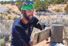  ?? ?? Thompson hangs a sign for the labyrinth he built in the Arroyo Chamisa in Santa Fe.