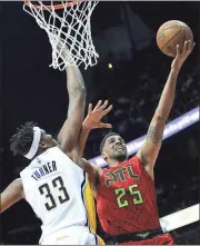  ??  ?? Branden Camp / The Associated Press
Atlanta forward Thabo Sefolosha (right) goes in for a layup while being defended by Indiana center Myles Turner.