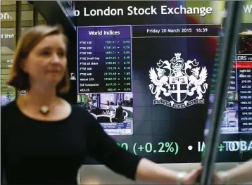  ??  ?? An informatio­n screen displays the FTSE 100 at the London Stock Exchange in Paternoste­r Square, London