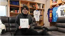  ?? — AFP photos ?? This photo taken on Jan 30, 2023 shows Japanese cartoonist and manga artist Yoichi Takahashi, best known for his work “Captain Tsubasa”, displaying his autograph with a painting of the main character following an interview with AFP at his workplace in Tokyo.