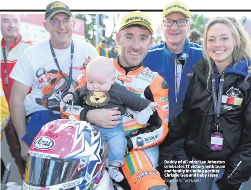  ??  ?? Daddy of all wins: Lee Johnston celebrates TT victory with team and family including partner Chrissie Gee and baby Jesse