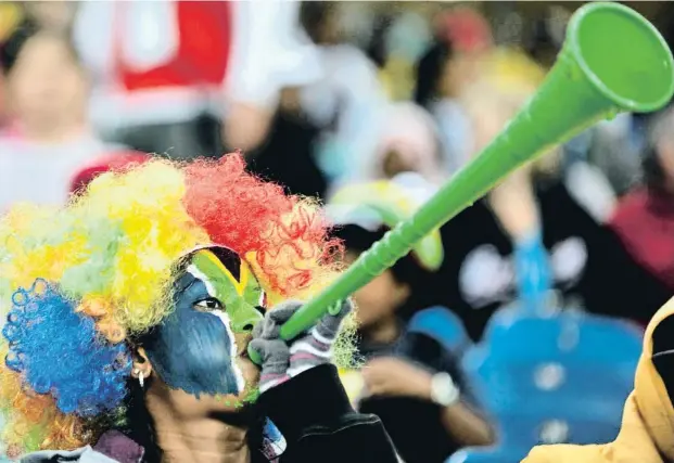  ?? ARIS MESSINIS / AFP ?? Arriba, un aficionado local sopla con fuerza su vuvuzela, artilugio que se convertirí­a en una de las señas de identidad de aquel Mundial