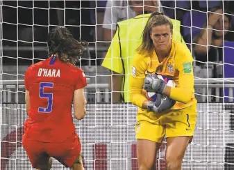  ?? Franck Fife / AFP / Getty Images ?? U.S. goalkeeper Alyssa Naeher smothers the ball after coming up with the save of a penalty kick late in Tuesday’s semifinal match against England as Kelley O’Hara rushes in to celebrate.