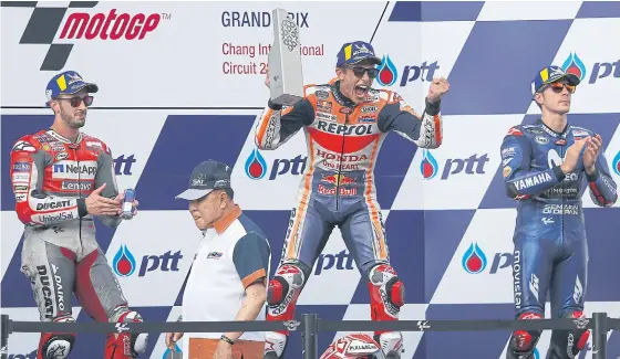  ??  ?? Champion Marc Marquez of Honda, centre, celebrates on the podium with runner-up Andrea Dovizioso of Ducati, left, and third-placed Maverick Vinales of Yamaha.