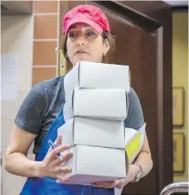  ?? DARIO AYALA ?? Hamantasch­en baking event organizer Eve Rochman carries boxes of hamantasch­en, prepared for the Jewish holiday of Purim, at Congregati­on Shaar Hashomayim in Westmount on Sunday.