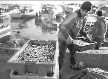  ?? KHALIL HAMRA/AP ?? Palestinia­n fishermen unload their catch at the Gaza Seaport after a night fishing trip.