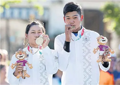  ??  ?? Golfers Atthaya Thitikul, left, and Vanchai Luangnitik­ul pose with the gold medals in the mixed team event.