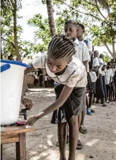  ?? Foto: Mark Naftalin, Unicef, AP, dpa ?? Schulkinde­r in der Millionen Stadt Mbandaka waschen sich zum Schutz die Hände, bevor sie in ihr Klassenzim­mer gehen.