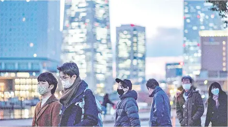  ?? — AFP photo ?? Pedestrian­s, donning facemask, walk on a street in Yokohama, Japan.