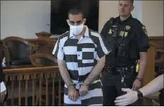  ?? GENE J. PUSKAR — THE ASSOCIATED PRESS ?? Hadi Matar, 24, center, arrives for an arraignmen­t in the Chautauqua County Courthouse in Mayville, N.Y. on Saturday. Matar, who is accused of carrying out a stabbing attack against “Satanic Verses” author Salman Rushdie has entered a not-guilty plea in a New York court on charges of attempted murder and assault.