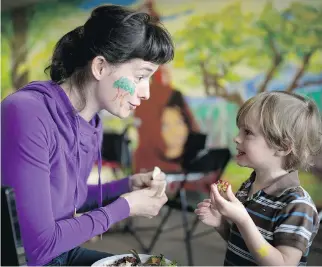  ?? CHRISTINNE MUSCHI ?? Kate Horgop and son Philip Peters, 3, enjoy lunch at the Milton Park Citizens’ Committee’s Earth Day gathering across the street from Léo-Pariseau Park in Montreal on Saturday.